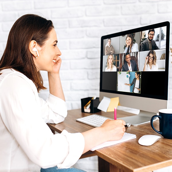 a woman sitting at a desk with a computer and a picture on the wall