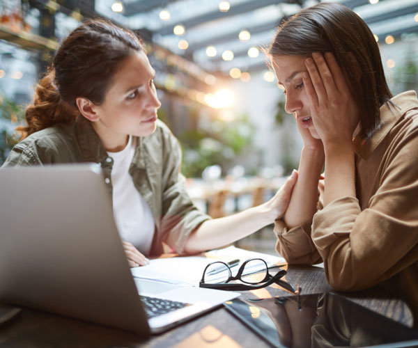 a person and a girl looking at a laptop